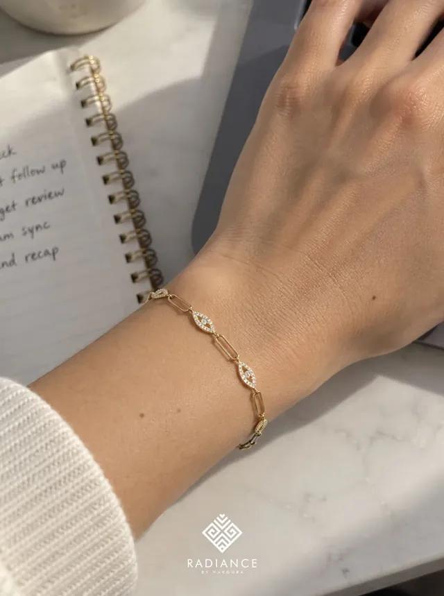 Radiance by Hakoura — gold bracelet over a handwritten journal