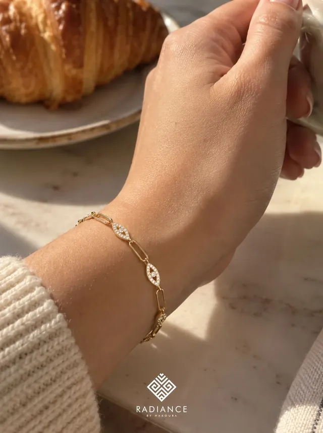 Radiance by Hakoura — gold bracelet over coffee and a croissant
