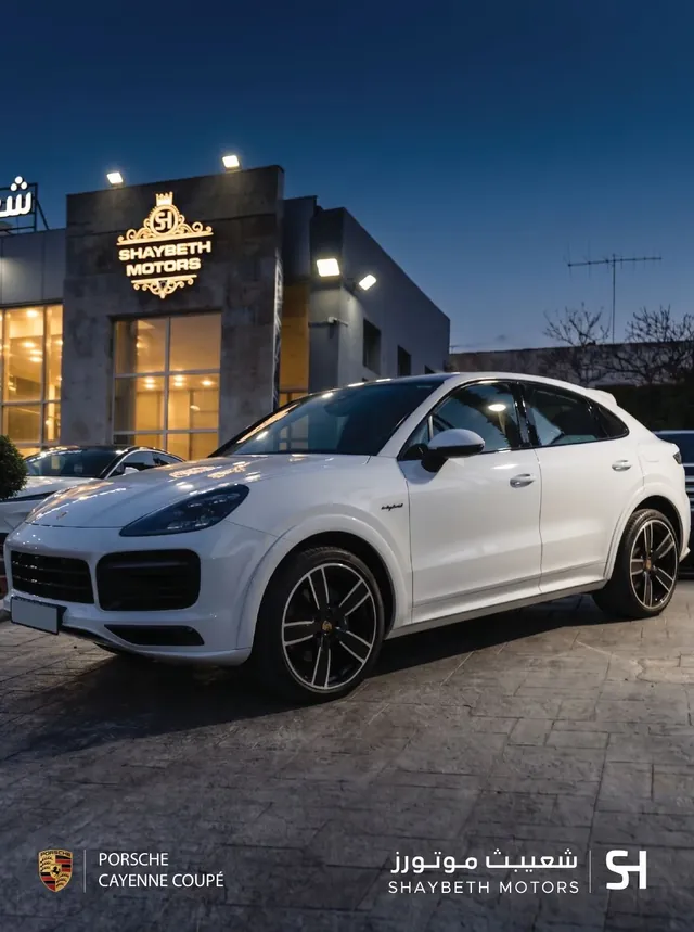 Shaybeth Motors — Porsche Cayenne Coupé outside the showroom at dusk